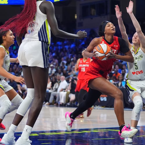 Atlanta Dream forward Angel Reese, center, drives against Dallas Wings guard Paige Bueckers (5) during the second half of a WNBA basketball game in Arlington, Texas, Wednesday, July 29, 2026. (AP Photo/LM Otero)