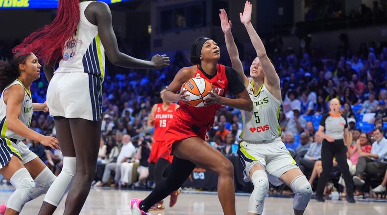 Atlanta Dream forward Angel Reese, center, drives against Dallas Wings guard Paige Bueckers (5) during the second half of a WNBA basketball game in Arlington, Texas, Wednesday, July 29, 2026. (AP Photo/LM Otero)
