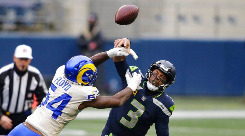Los Angeles Rams outside linebacker Leonard Floyd (54), a former University of Georgia star, knocks the ball away as Seattle Seahawks quarterback Russell Wilson tries to pass during the first half of an NFL wild-card playoff football game, Saturday, Jan. 9, 2021, in Seattle. (AP Photo/Scott Eklund)