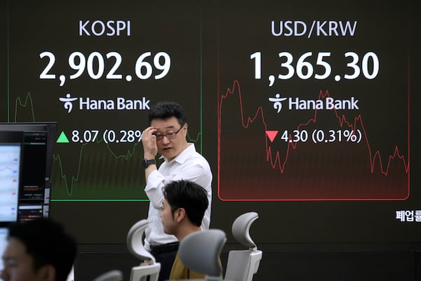 Currency traders work near a screen showing the Korea Composite Stock Price Index (KOSPI), left, and the foreign exchange rate between U.S. dollar and South Korean won at the foreign exchange dealing room of the KEB Hana Bank headquarters in Seoul, South Korea, Monday, June 16, 2025. (AP Photo/Ahn Young-joon)