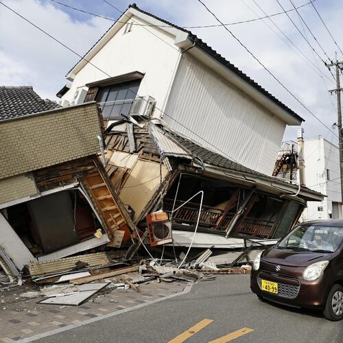 A vehicle passes by collapsed houses after an earthquake in Yatsushiro, Kumamoto prefecture, Wednesday, July 29, 2026.(Juntaro Yokoyama/Kyodo News via AP)