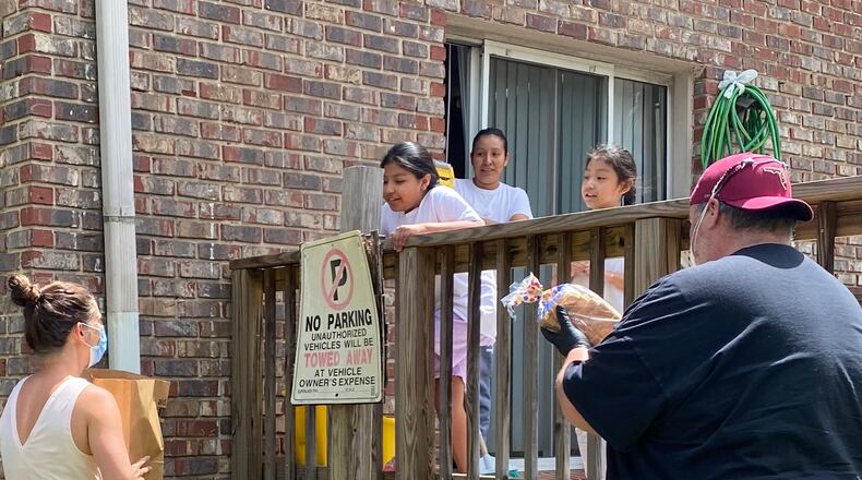 Lake Forest Elementary teacher Nicole Gray (far left) delivers food to a family in need through the Lion Pride nonprofit she founded.