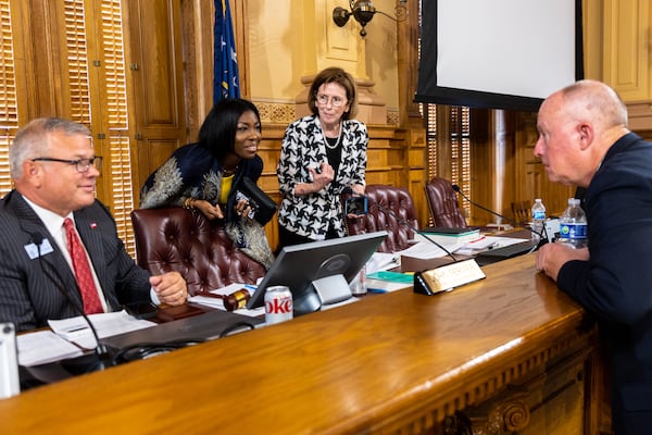 (L-R) State Election Board Executive Director Mike Coan and members Janelle King, Janice Johnston, and Rick Jeffares speak during a break at the board meeting at the Capitol in Atlanta on Tuesday, July 9, 2024. (Arvin Temkar / AJC)