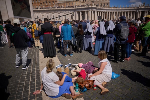 Faithful listen to mass during the funeral of Pope Francis in St. Peter's Square at the Vatican, Saturday, April 26, 2025. (AP Photo/Emilio Morenatti)