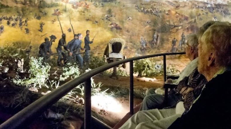 Visitors in this 2013 photograph look at different scenes from the Battle of Atlanta depicted in the Cyclorama painting in Grant Park. The attraction is closing at the end of June in preparation for its relocation and restoration at the Atlanta History Center.. JONATHAN PHILLIPS / SPECIAL