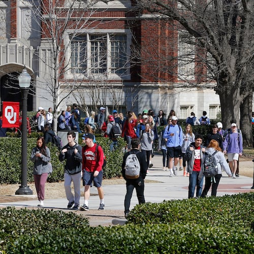 FILE - People walk on the Oval at the University of Oklahoma in Norman, Okla., Tuesday, March 10, 2015. (AP Photo/Sue Ogrocki, File)