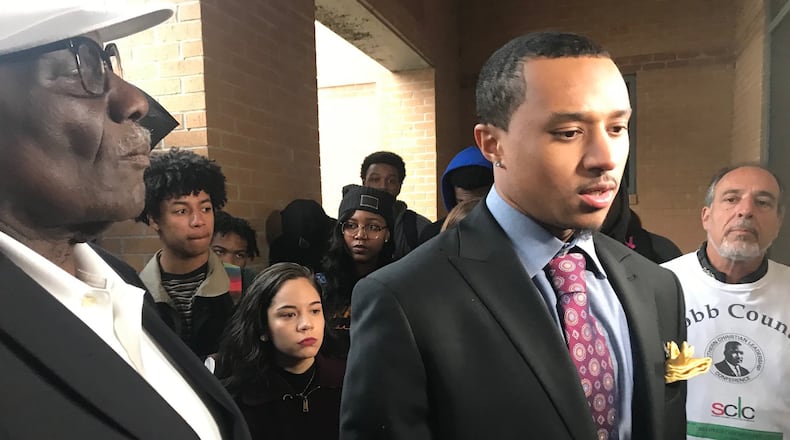 Students and supporters of Kennesaw State University student Elijah John (center) look on as he talks to reporters on Tuesday about a racist social media post he says targeted him. ERIC STIRGUS / ESTIRGUS@AJC.COM
