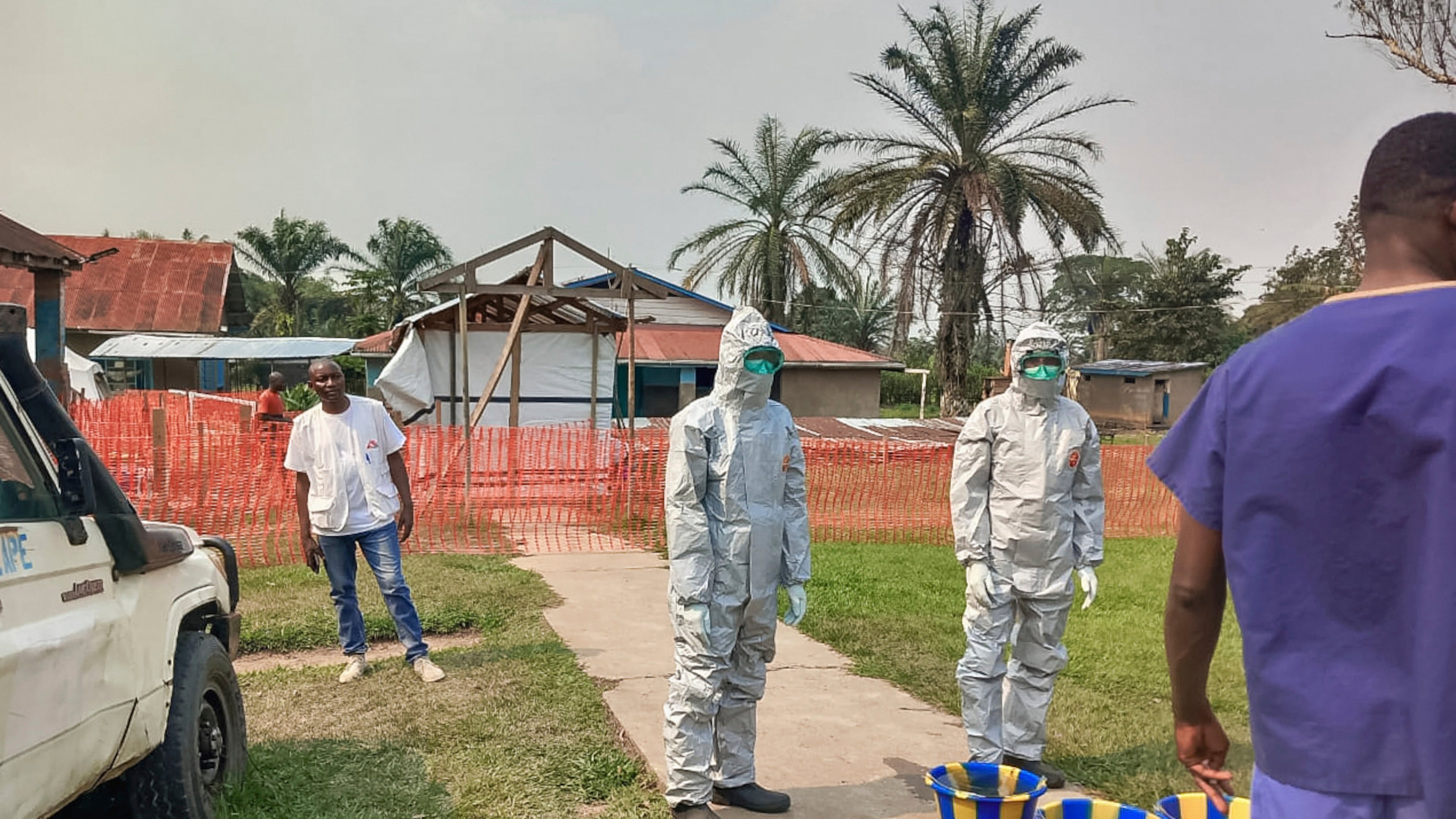 In this photo provided by Doctors Without Borders, men stand outside an Ebola treatment center in the remote Bulape Health Zone, Kasaï province, the Democratic Republic of Congo, Sunday, Sept 7, 2025, that was set up following the outbreak of the Zaire strain of the Ebola virus. (MSF via AP)