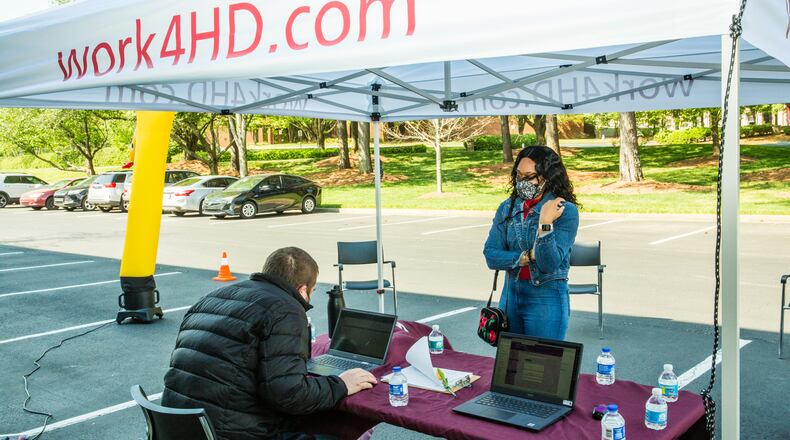 Hire Dynamics hosts their Hirepalooza at their Austell location on Wednesday, April 21, 2021.  Job seeker Gerrisa Morgan, checks in at the desk outside. The staffing agency has adapted to the pandemic with outdoor options and is busy hiring people for clients like Dole, Walmart and many others.   (Jenni Girtman for The Atlanta Journal-Constitution)