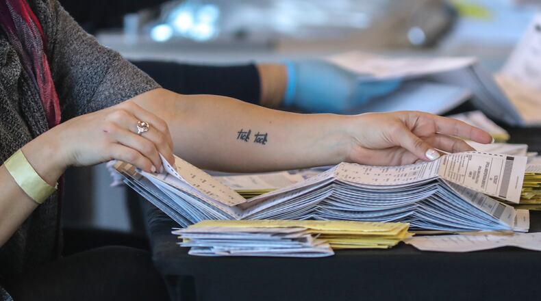 Fulton County election workers tally absentee ballots in November. A judge may unseal the ballots to allow a government watchdog to investigate claims of fraud. (John Spink / John.Spink@ajc.com)