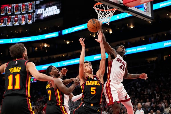 Miami Heat guard Davion Mitchell (45) and Atlanta Hawks guard Dyson Daniels (5) both go for the rebound in the second half of an NBA play-in tournament basketball game, Friday, April 18, 2025, in Atlanta. (AP Photo/Brynn Anderson)
