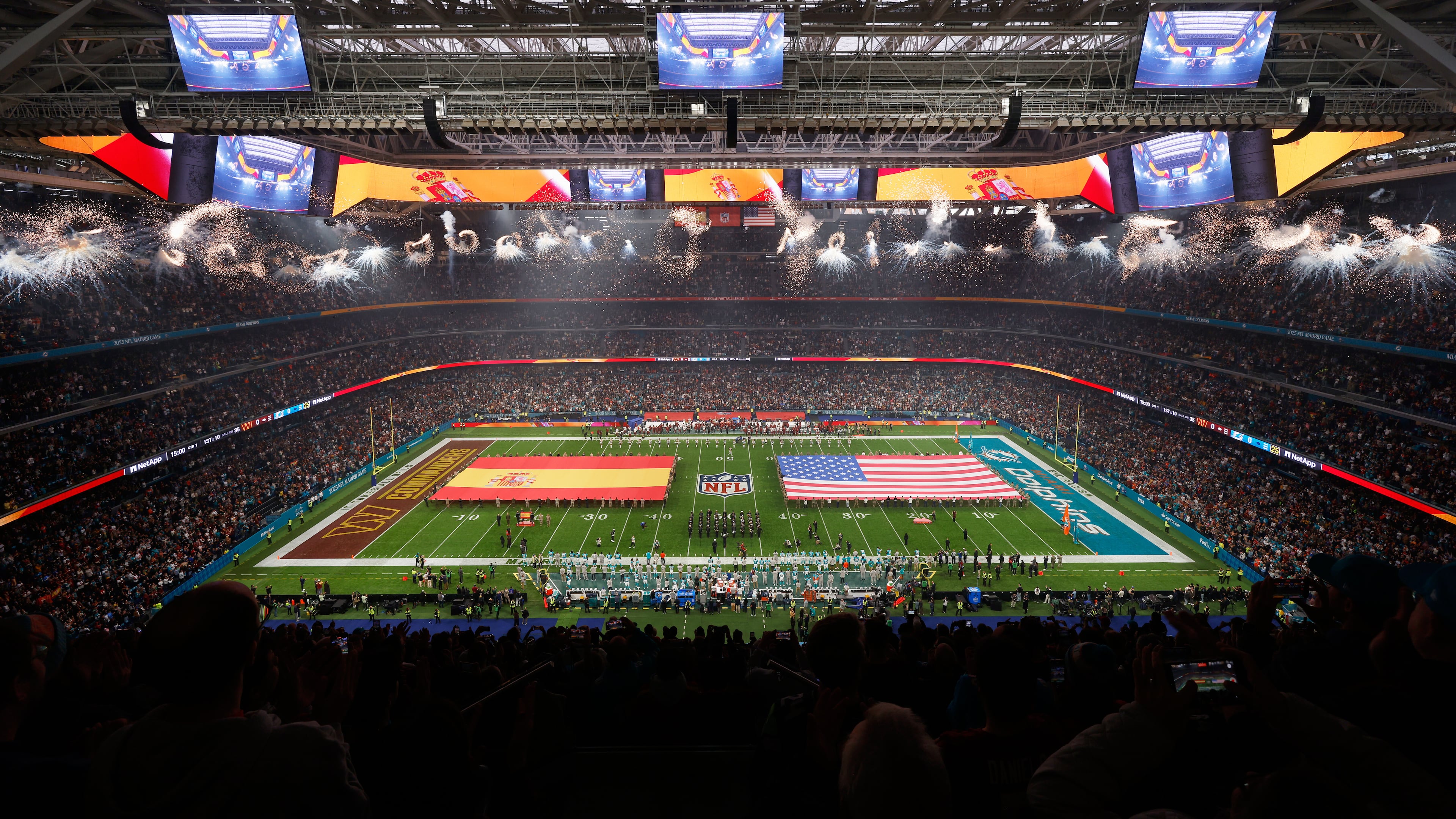 An overall, interior, general view of the Santiango Bernabeu stadium during the singing of the national anthems before an NFL football game between the Miami Dolphins and the Washington Commanders in Madrid, Spain, Sunday, Nov. 16, 2025. (AP Photo/Manu Reino)