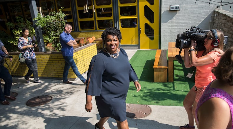 Democratic gubernatorial candidate Stacey Abrams, center, leaving a press conference last month. ALYSSA POINTER/ALYSSA.POINTER@AJC.COM