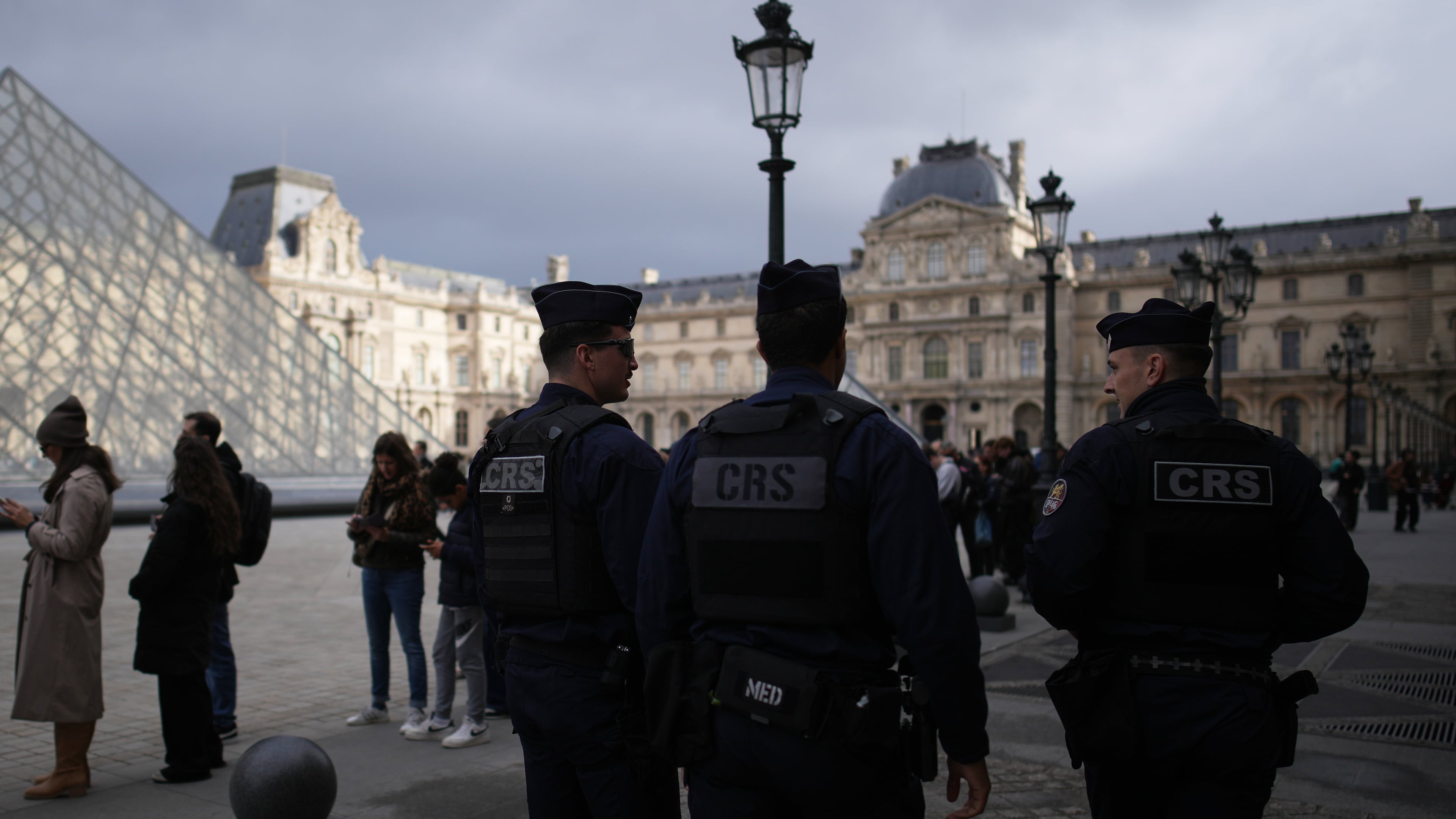 Riot police officers patrol as people queue to enter Le Louvre museum Monday, Oct. 27, 2025 in Paris. (AP Photo/Christophe Ena)