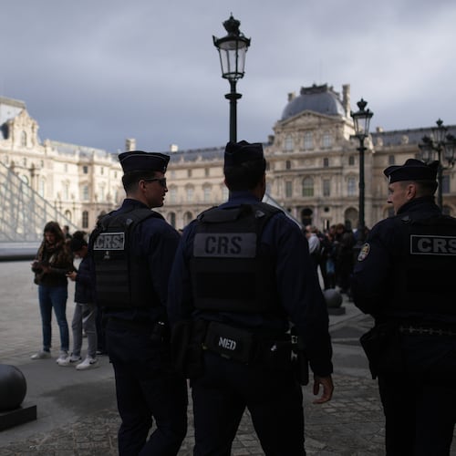 Riot police officers patrol as people queue to enter Le Louvre museum Monday, Oct. 27, 2025 in Paris. (AP Photo/Christophe Ena)