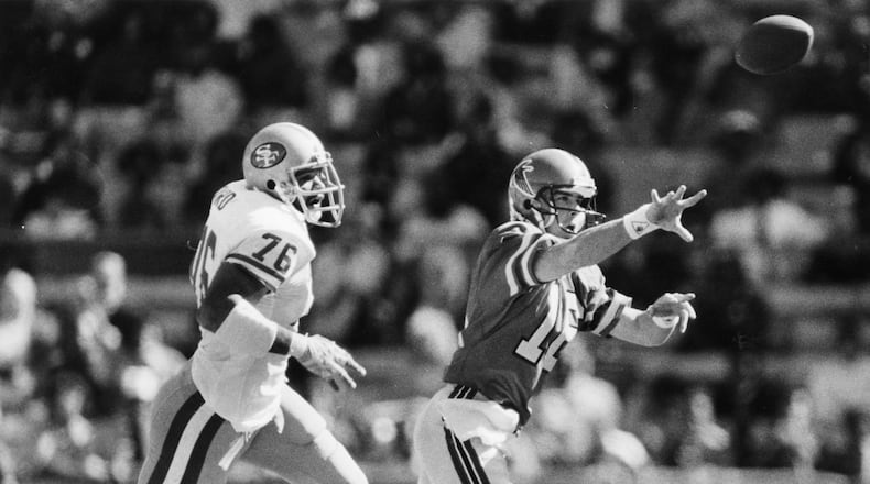 Archer dumps the ball to a close teammate before being sacked by the 49ers in 1985. Louie Favorite / AJC