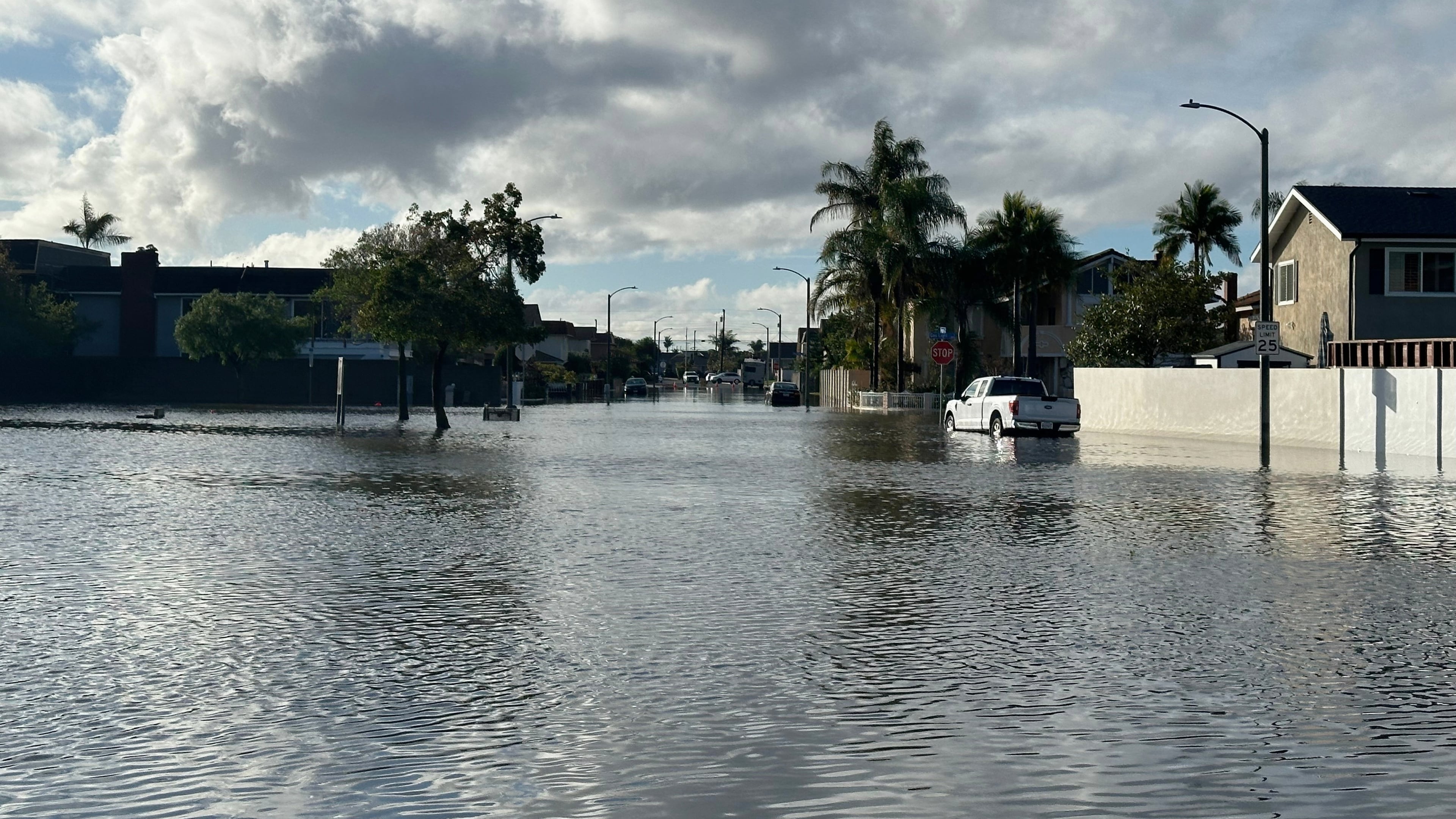 A local pond overflows into a residential neighborhood in Huntington Beach, Calif. following a storm on Friday, Nov. 21, 2025. (AP Photo/Amy Taxin)