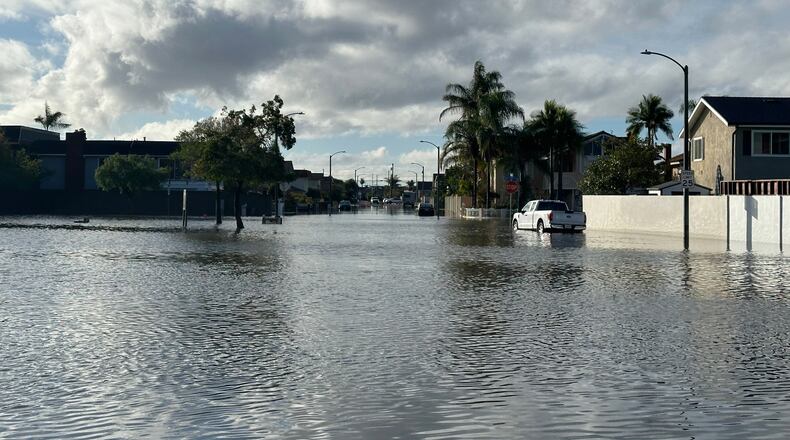 A local pond overflows into a residential neighborhood in Huntington Beach, Calif. following a storm on Friday, Nov. 21, 2025. (AP Photo/Amy Taxin)
