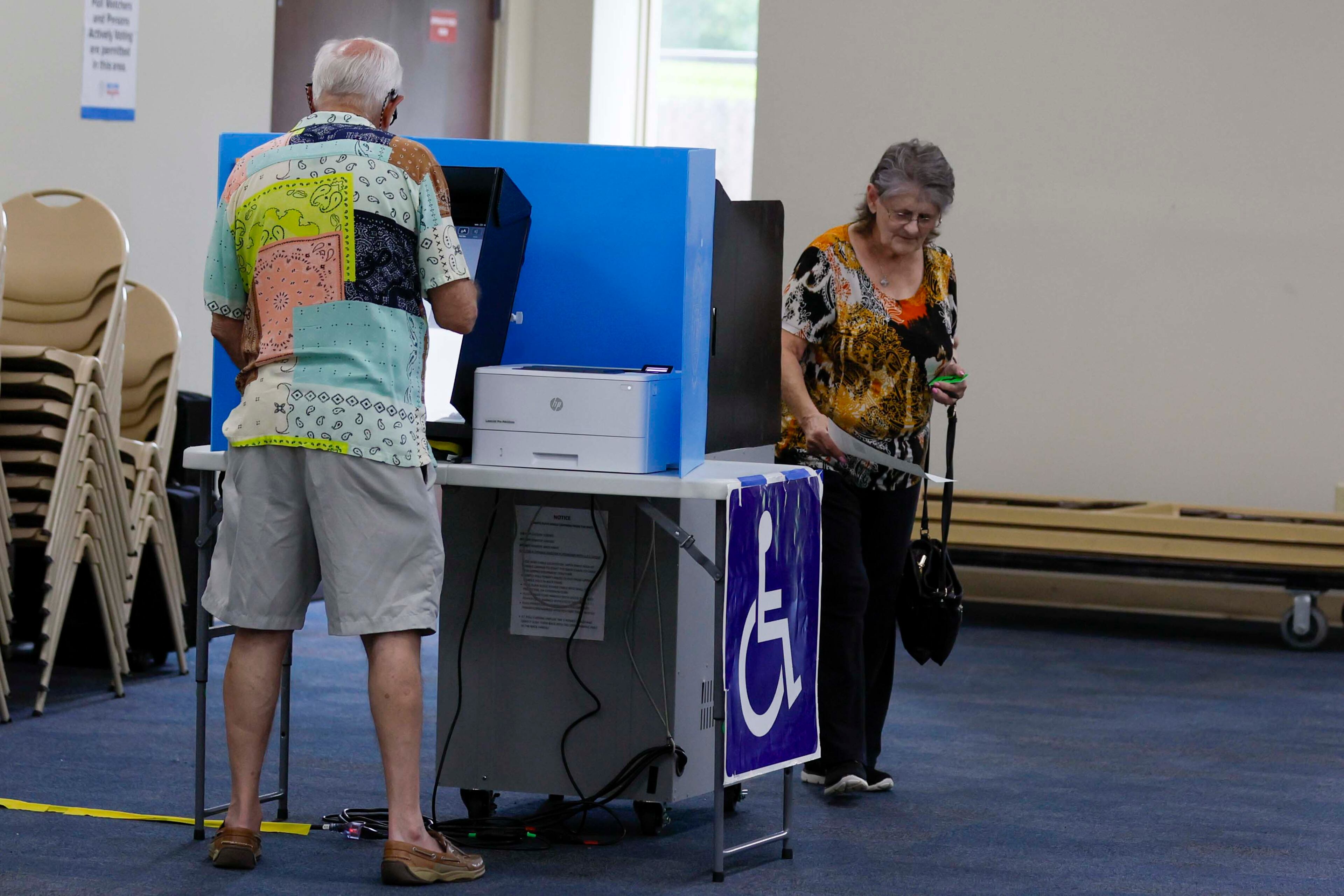 Marie Harvey holds her ballot as her husband, Nathan Harvey votes during the Georgia Public Service Commission’s special election at Ron Anderson Community Center in Cobb County.
(Miguel Martinez/AJC)