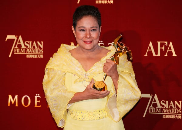 FILE - Philippine actress Nora Aunor poses with her trophy after winning the Best Actress Award for her movie "Thy Womb" at the Asian Film Awards during the 37th Hong Kong International Film Festival in Hong Kong on March 18, 2013. (AP Photo/Kin Cheung, File)