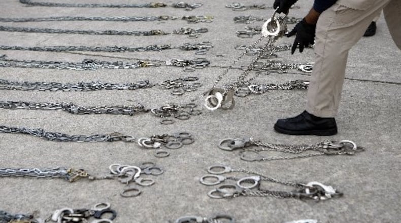 A U.S. Immigration and Customs Enforcement agent prepares shackles to restrain 100 people on a deportation flight out of Atlanta on Thursday, May 3, 2012. Curtis Compton/ccompton@ajc.com