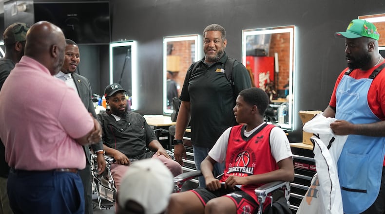 Khalil Thompson, center, co-founder of Win With Black Men, leads a discussion at Philly Cuts barber shop in Philadelphia, Friday, Aug. 21, 2026. (AP Photo/Matt Rourke)