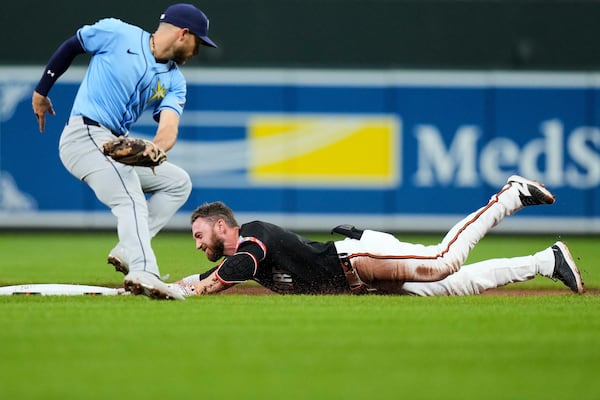 Baltimore Orioles' Jordan Westburg, right, slides into second base in front of Tampa Bay Rays shortstop Jose Caballero, left, after hitting a double during the first inning of a baseball game, Friday, June 27, 2025, in Baltimore. (AP Photo/Stephanie Scarbrough)
