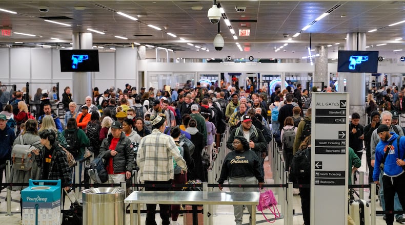 Travelers line up in the main security checkpoint at Hartsfield Jackson International Airport during a busy holiday season. (Ben Hendren for the AJC 2023)