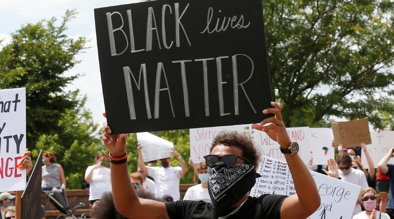 Atlanta Hawks guard Trae Young, right, holds a "Black Lives Matter" sign at a peaceful rally Monday, June 1, 2020, in his hometown of Norman, Okla., calling attention to the killing of George Floyd by Minneapolis police on May 25. (AP Photo/Sue Ogrocki)