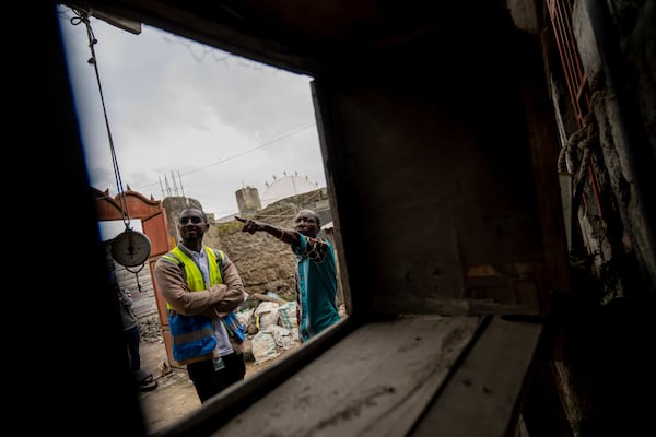 Choma Choma Mayuto Banga, right, who uses power at his home from a solar energy, talks with a customer service representative in Goma, Congo, May 23, 2024. (AP Photo/Moses Sawasawa)