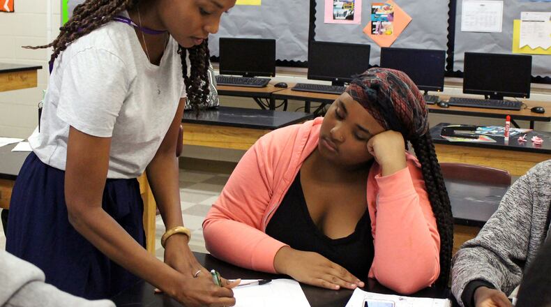 Sascha Brown (left) helps her student Alexia Mitchell during their environmental science class at the S.T.E.A.M. Academy at Carver High School on Thursday, Aug. 2. The S.T.E.A.M. Academy at Carver High School started the new year with its new project-based program. JENNA EASON / Jenna.Eason@coxinc.com