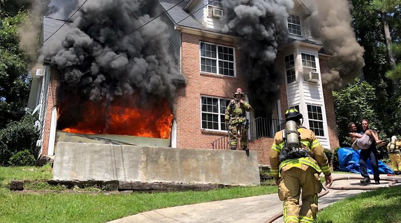 Officials released this photograph of a woman being carried from a house fire in DeKalb County on Tuesday.
