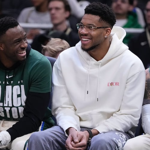 Milwaukee Bucks' Giannis Antetokounmpo smiles on the bench with Thanasis Antetokounmpo during the first half of an NBA basketball game Wednesday, Feb. 4, 2026, in Milwaukee. (AP Photo/Morry Gash)