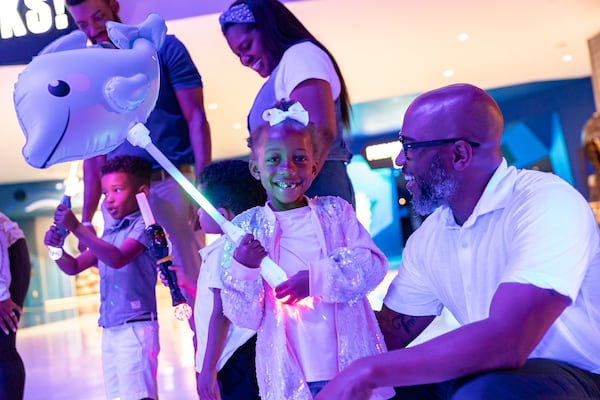 A child holds a glowing dolphin during a dress rehearsal of Georgia Aquarium's Glow Nights, which will open May 30. Courtesy of Addison-Hill