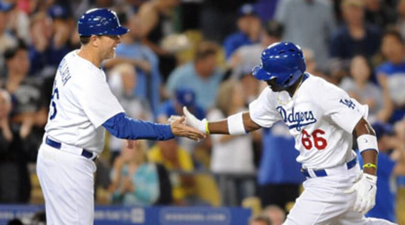 The Los Angeles Dodgers' Yasiel Puig (66) is congratulated by third base coach Tim Wallach after hitting a game-tying home run against the Atlanta Braves in the sixth inning at Dodger Stadium in Los Angeles, California, on Friday, June 7, 2013. (Wally Skalij/Los Angeles Times/MCT)
