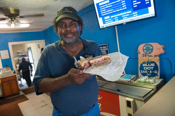 Owner J. Byron Long presents one of Blue Dot's greasy, barbecue-sauced burgers. 
Courtesy of Visit Pensacola