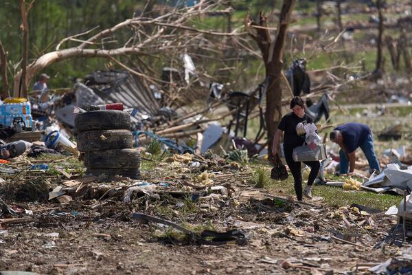 Macey Coffey carries salvageable items from what isleft of Edwina Wilson's destroyed home, Sunday, May 18, 2025, in London, Ky., after a severe storm passed through the area. (AP Photo/Carolyn Kaster)