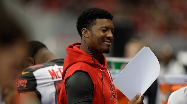 An injured Tampa Bay Buccaneers quarterback Jameis Winston stands on the sidelines during the first half of an NFL football game between the Atlanta Falcons and the Tampa Bay Buccaneers, Sunday, Nov. 26, 2017, in Atlanta. (AP Photo/Chris O'Meara)