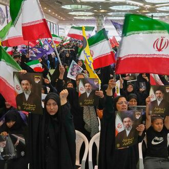 Government supporters hold Iranian flags and pictures of Iran's Supreme Leader, Ayatollah Mojtaba Khamenei, during a ceremony honoring the armed forces and those killed in the war with Israel and the U.S. at the Imam Khomeini Grand Mosque in Tehran, Iran, Sunday, May 24, 2026. (AP Photo/Vahid Salemi)