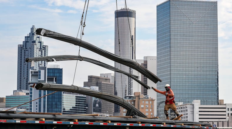 September 26, 2023 Atlanta: Miguel Flores sends off a bundle of rebar skyward by crane from his flatbed truck on Martin Luther King Jr. Drive in downtown Atlanta as work on Hotel Phoenix at Atlanta’s $5 billion Gulch redevelopment on Tuesday, Sept. 26, 2023.(John Spink / John.Spink@ajc.com)