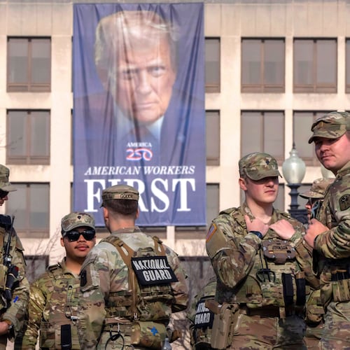 FILE - National Guard members gather near a large portrait of President Donald Trump on the Labor Department headquarters before the body of Metropolitan Police Department officer Terry Bennett is driven past the Capitol, Jan. 8, 2026, in Washington. (AP Photo/Mark Schiefelbein, File)