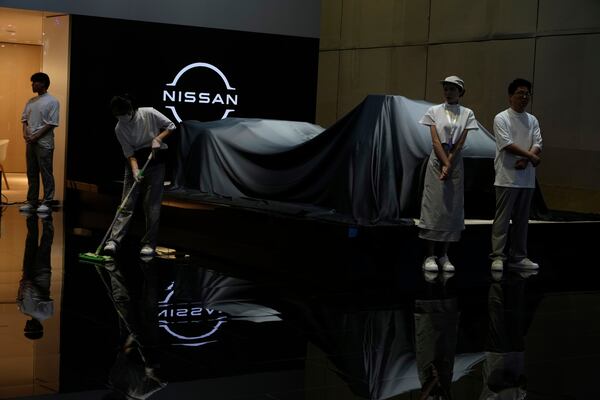 Exhibitors prepare for an unveiling at the Auto Show in Shanghai, Wednesday, April 23, 2025. (AP Photo/Ng Han Guan)