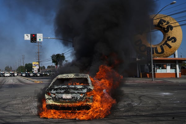 A car burns during a protest in Compton, Calif., Saturday, June 7, 2025, after federal immigration authorities conducted operations. (AP Photo/Eric Thayer)