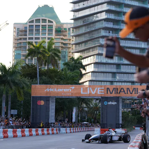 Fans watch as former Brazilian racing driver Bruno Senna steers an MP4/6 during a fan event showcasing past McLaren race cars ahead of the Formula One Miami Grand Prix auto race, Wednesday, April 29, 2026, in the Coconut Grove area of Miami. (AP Photo/Rebecca Blackwell)