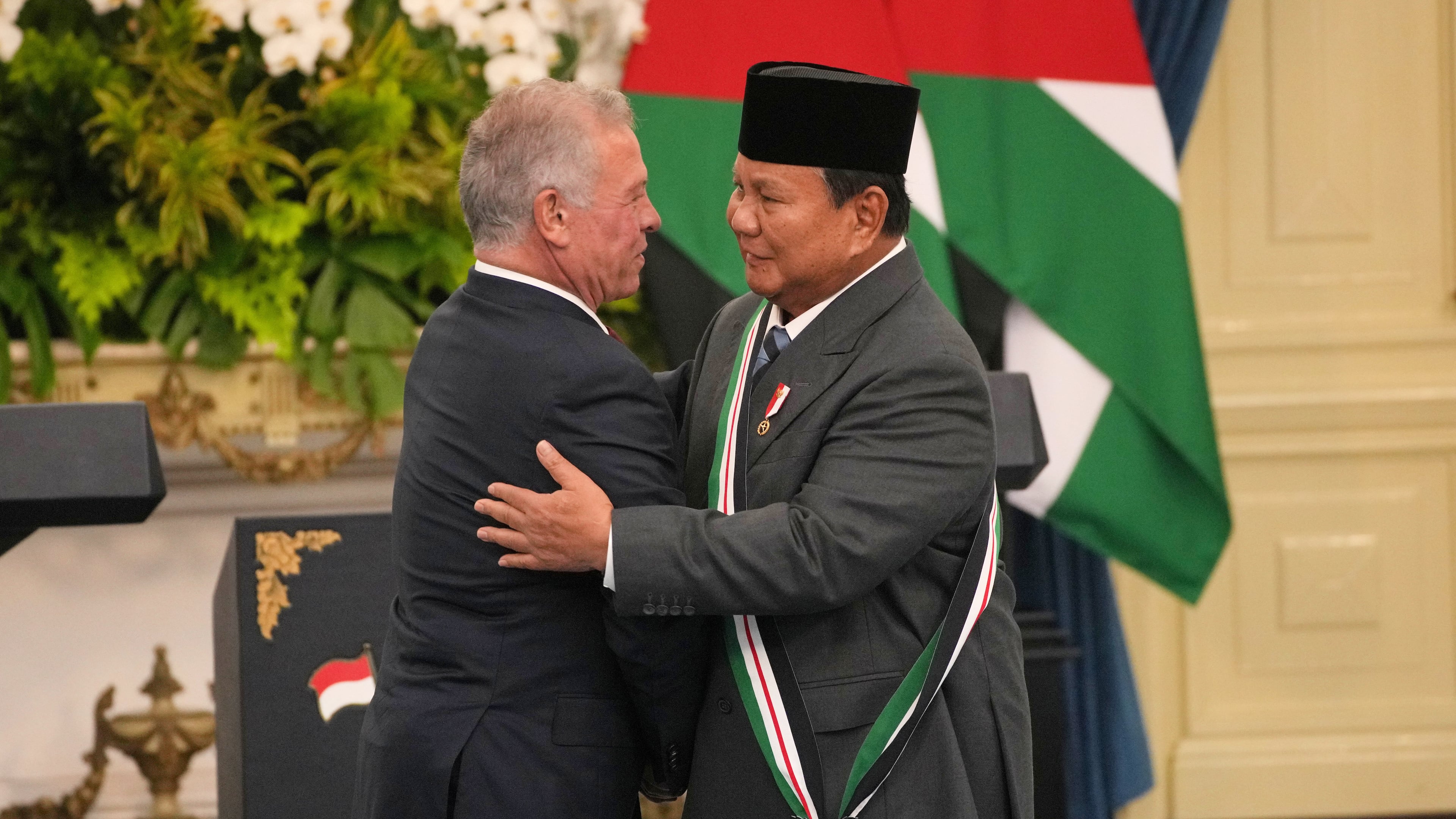 Jordanian King Abdullah II, left, hugs Indonesian President Prabowo Subianto after decorating him with the Order of the Bejewelled Grand Cordon of Al Nahda or the Supreme Order of the Renaissance, one of Jordan's high honors, during their meeting at Merdeka Palace in Jakarta, Indonesia, Friday, Nov. 14, 2025. (AP Photo/Achmad Ibrahim)