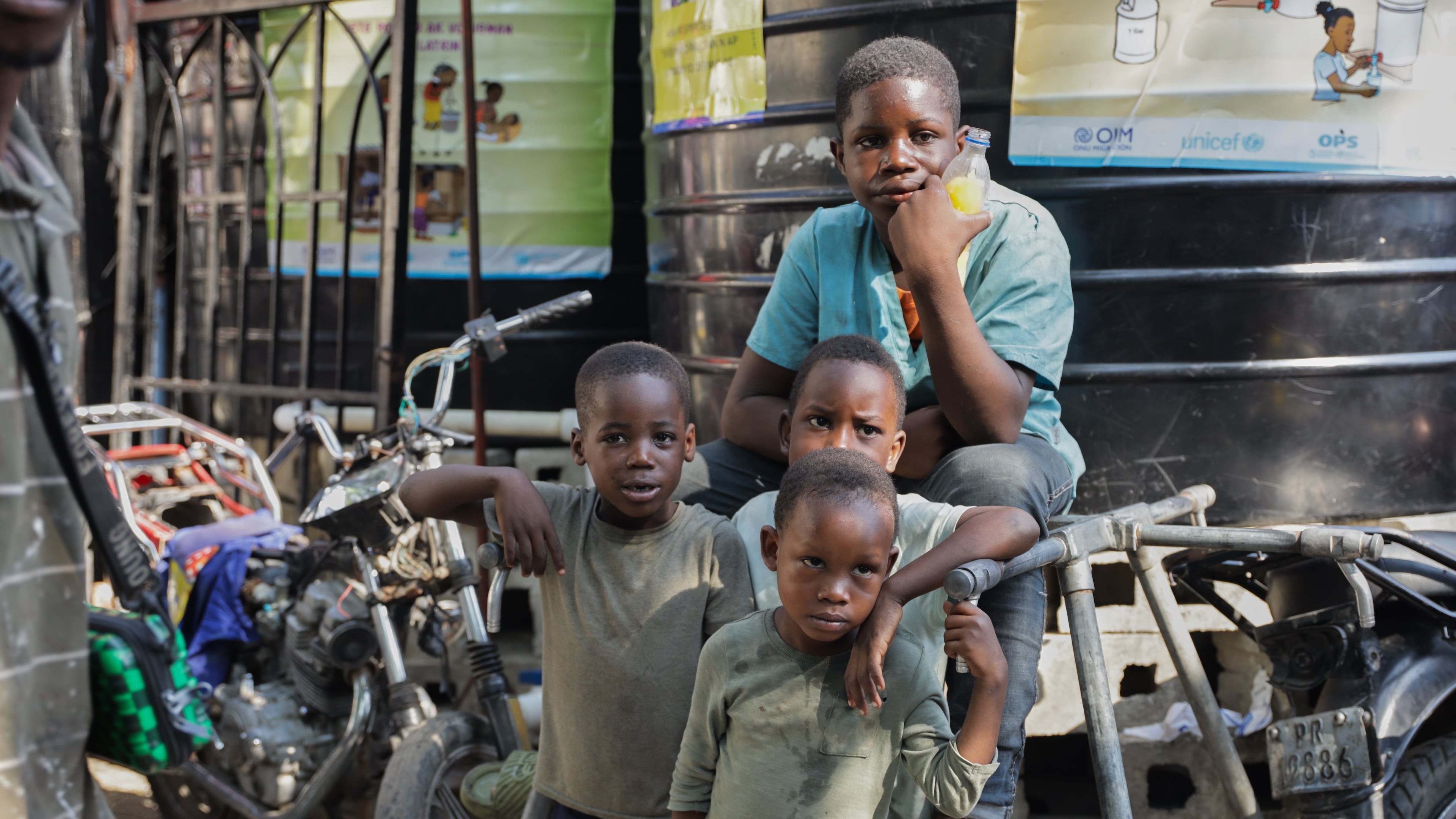 Children look at students attending school at a shelter for families displaced by gang violence in Port-au-Prince, Haiti, Tuesday, Oct. 7, 2025. (AP Photo/Patrice Noel)