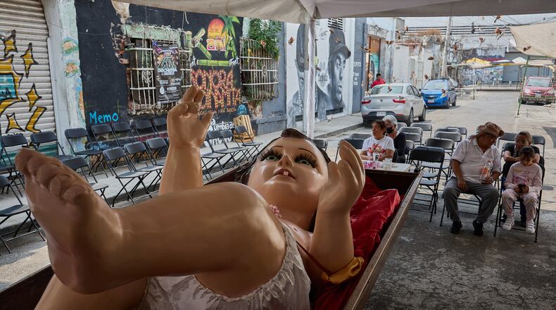 Parishioners take part in an offering to a giant Baby Jesus in Mexico City, Tuesday, March 10, 2026. (AP Photo/Ginnette Riquelme)