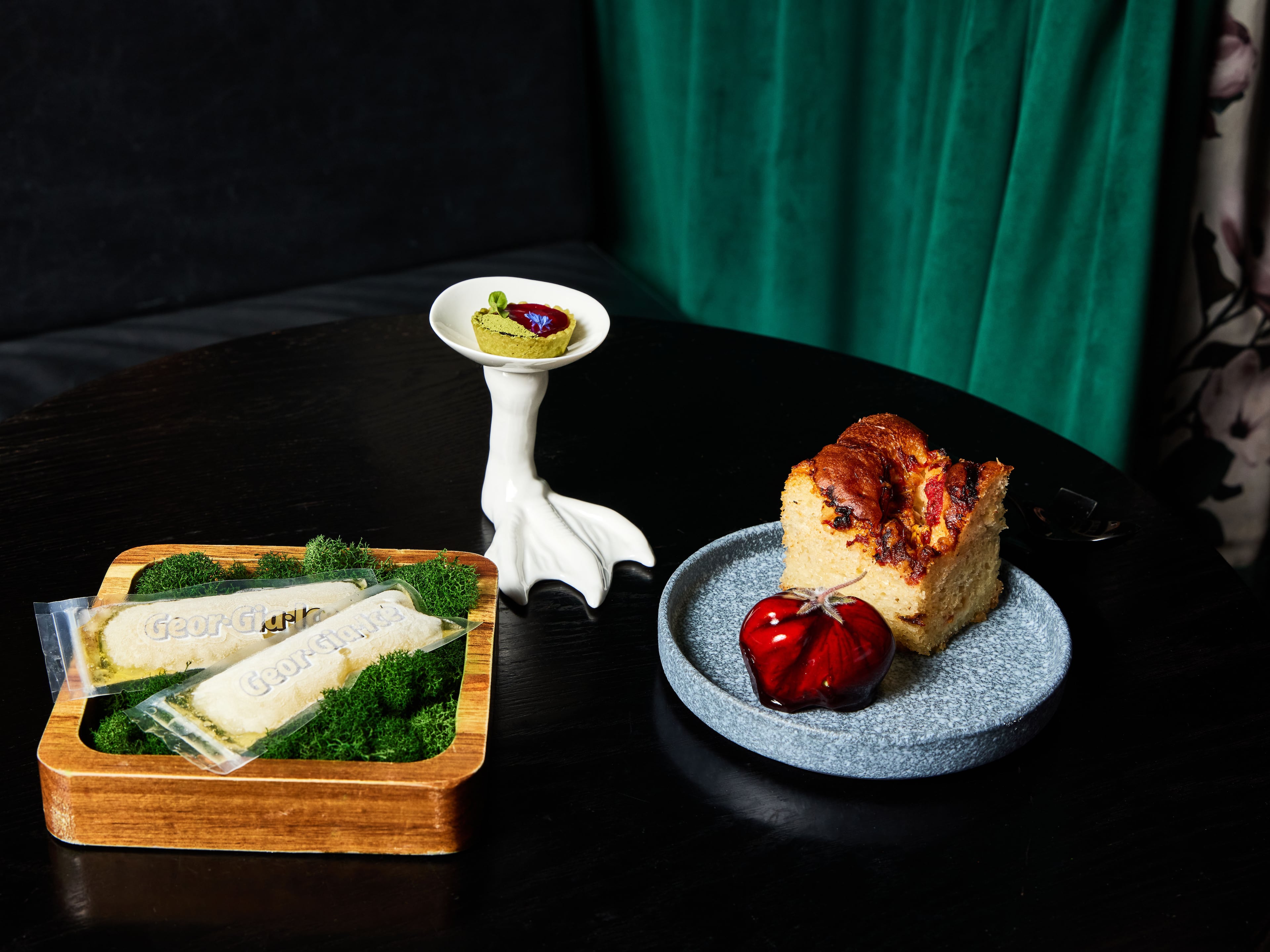 Georgia Boy reopened in 2021, after the pandemic. The name might sound "country," but the food is top notch. Try (on pedestal) the Honeysuckle Foie Gras Tart with red currant gelee, and the Rosemary Tomato Foccacia. (Styling by chef Joey Ward / Photo by Bailey Garrot for the AJC)