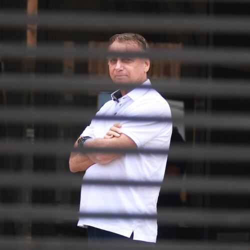FILE - Brazil's former President Jair Bolsonaro stands at the entrance of his home while he is under house arrest in Brasilia, Brazil, Sept. 2, 2025. (AP Photo/Luis Nova, File)