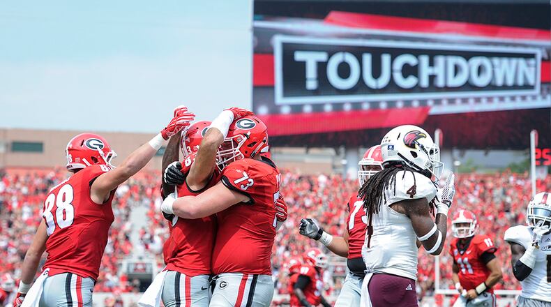 Georgia tight end Jackson Harris (88), tight end Jeb Blazevich (83), and guard Greg Pyke (73) celebrate a touchdown as Louisiana Monroe safety Tre' Hunter (4) walks away during the first half Saturday, Sept., 5, 2015, in Athens.